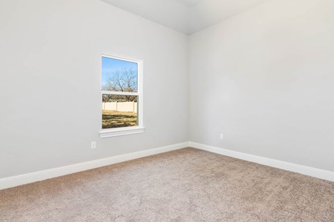 an empty room with a window and carpet