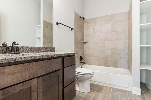 a bathroom with a toilet and a tub and a sink