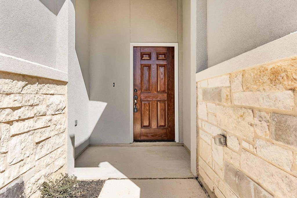 the entrance to a house with a wooden door