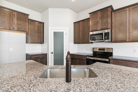 an empty kitchen with wooden cabinets and granite counter tops