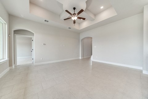 an empty living room with a ceiling fan