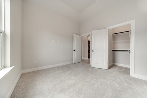 an empty bedroom with a closet and a window