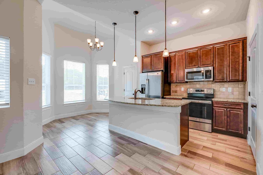 an empty kitchen with wooden cabinets and a counter top