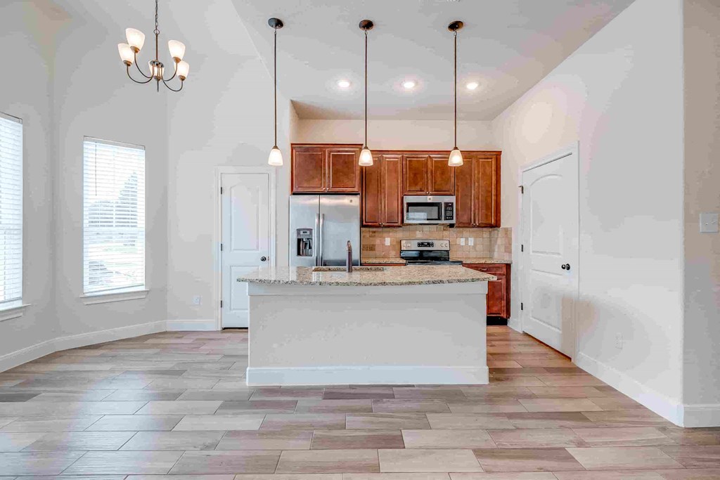 an empty kitchen with a large island in the middle