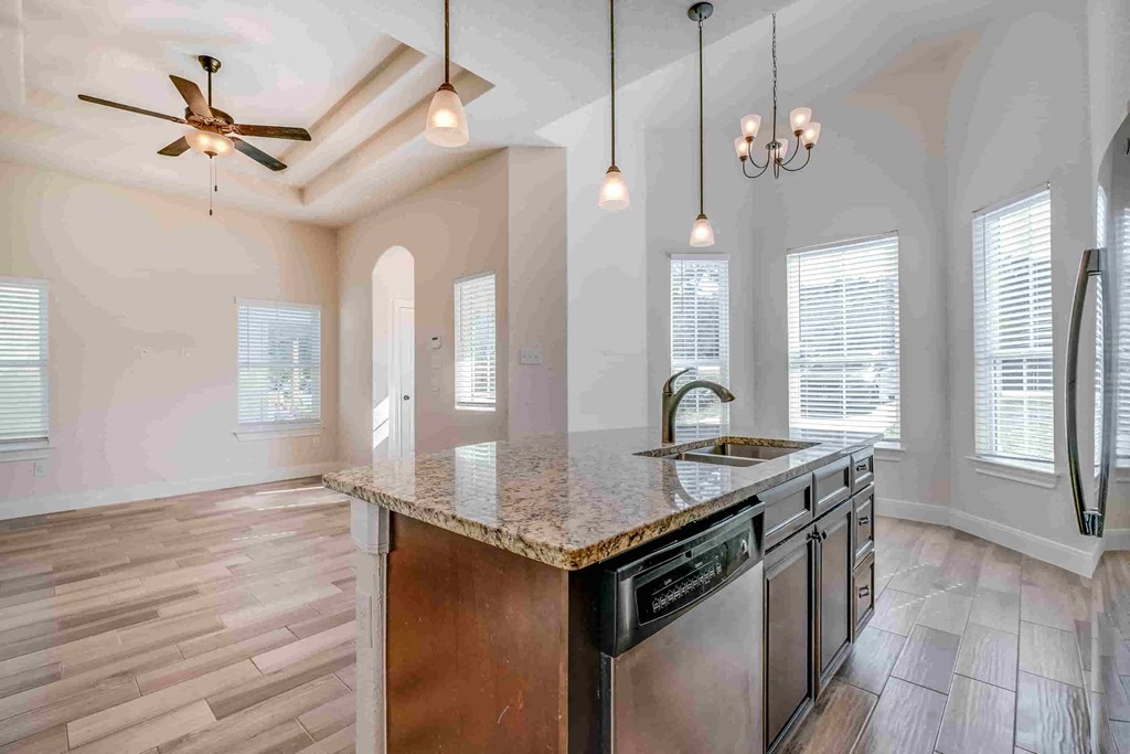 an empty kitchen with a sink and a counter top