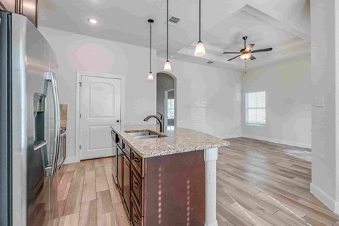 an empty kitchen with a sink and a counter top