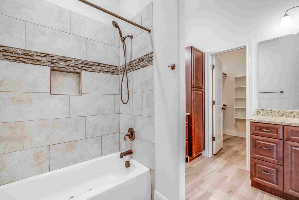 a bathroom with a tub and a shower and a sink