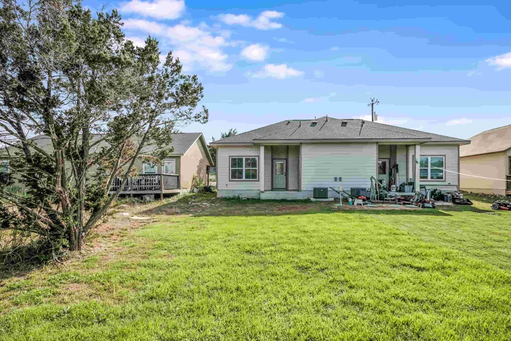 a white house with a yard and a fence in front of it