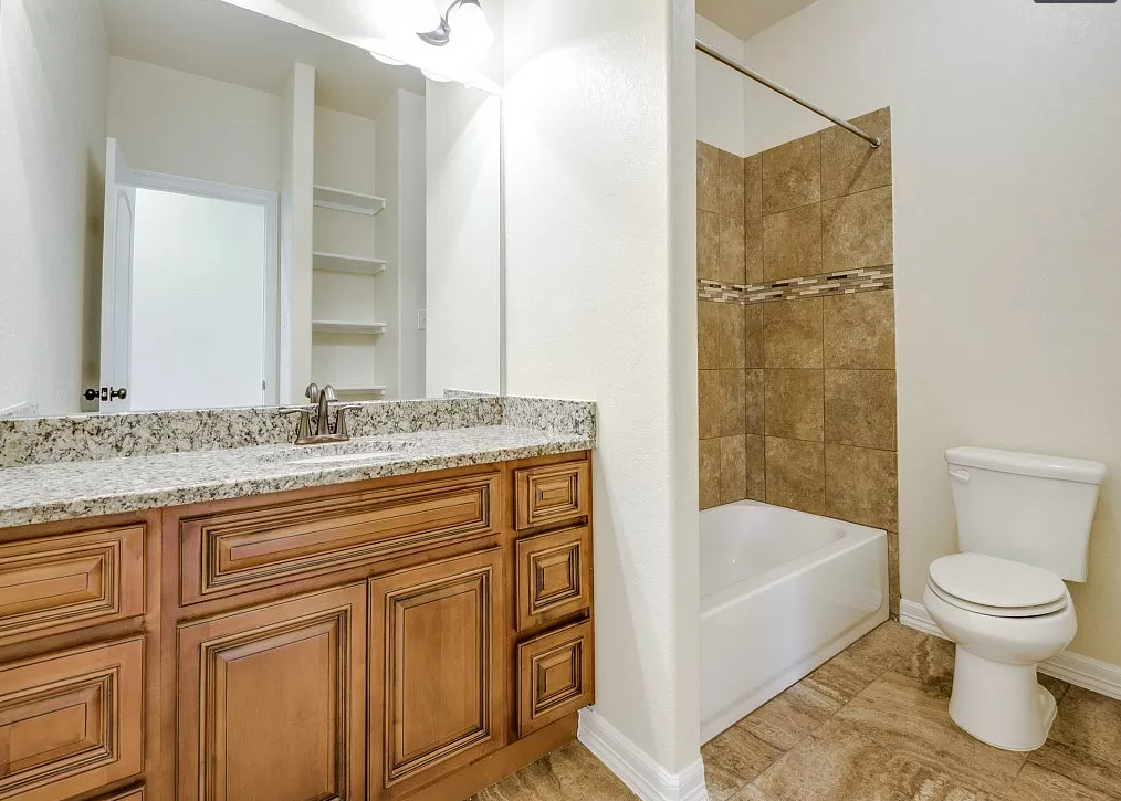 a bathroom with a toilet and a shower and a sink