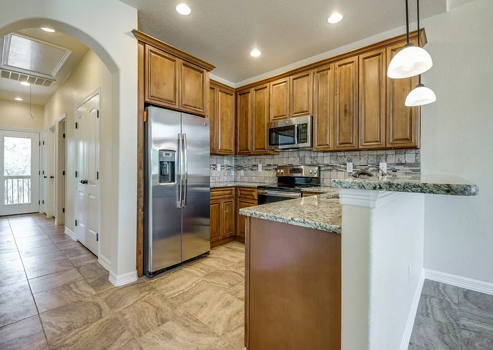 a kitchen with stainless steel appliances and wooden cabinets