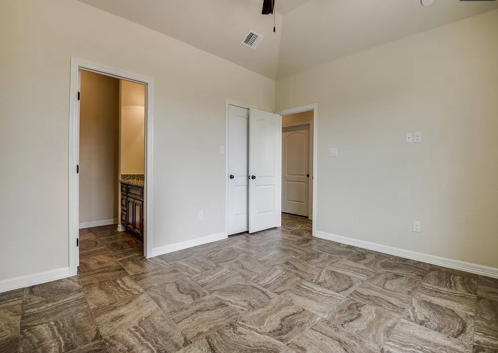 a living room with a door to a hallway and a closet