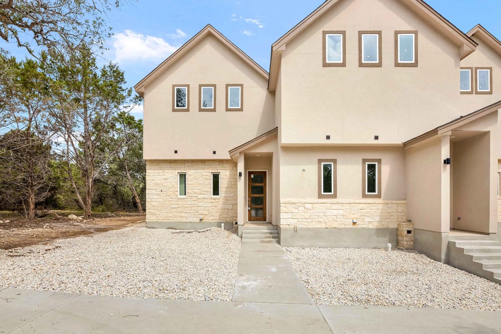 the front of a house with a gravel driveway