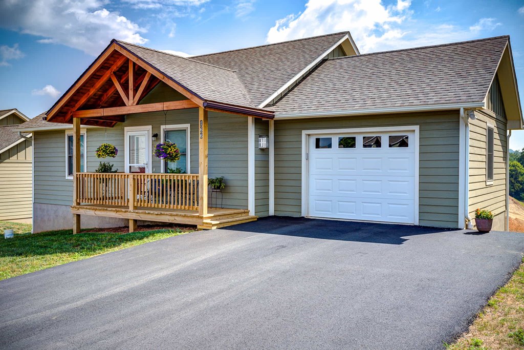 A house with a white garage door and a brown porch.