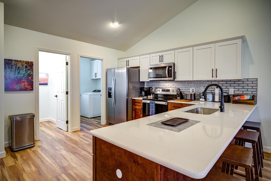 A kitchen with a white counter top and wooden cabinets.