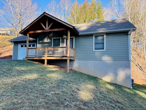 a blue house with a deck on the side of it