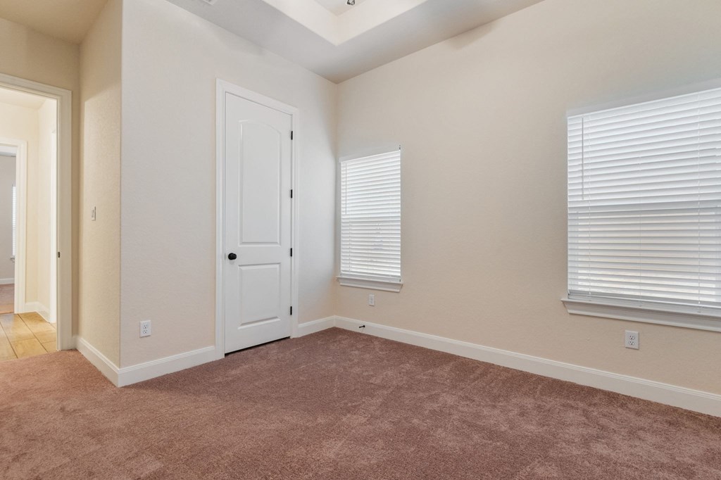 the living room of a home with a carpet and a white door