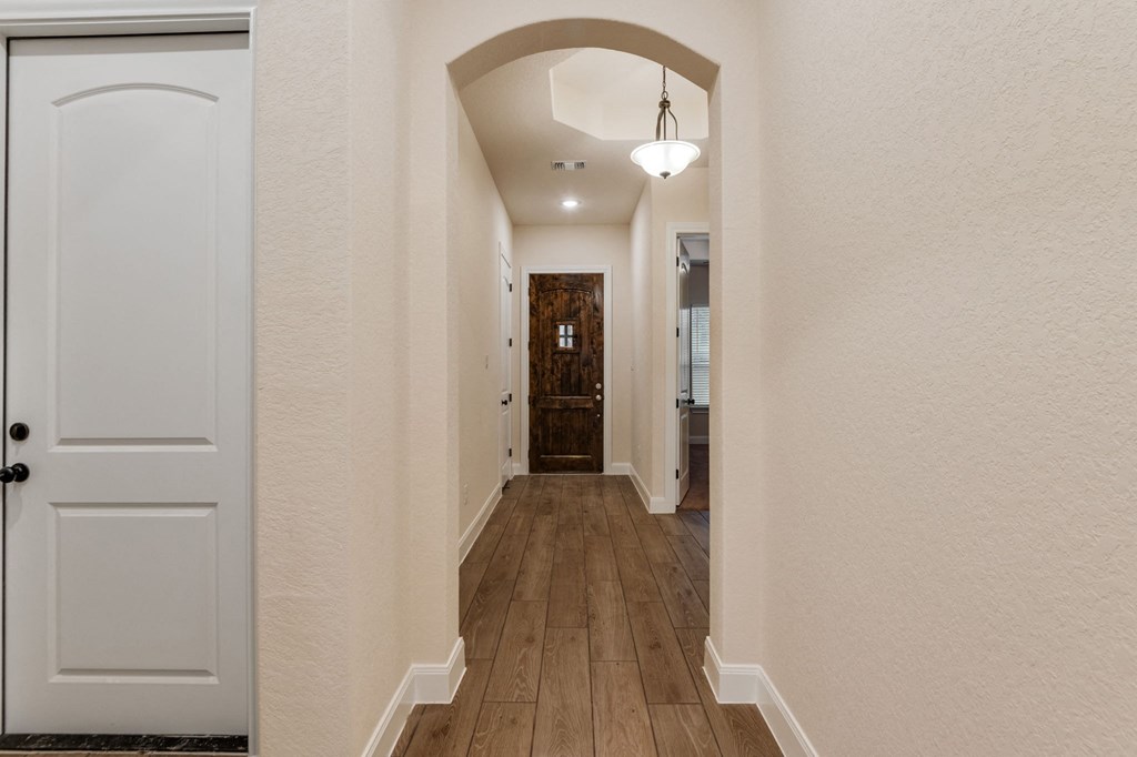 the hallway of a house with a door to a bathroom and a hallway with a