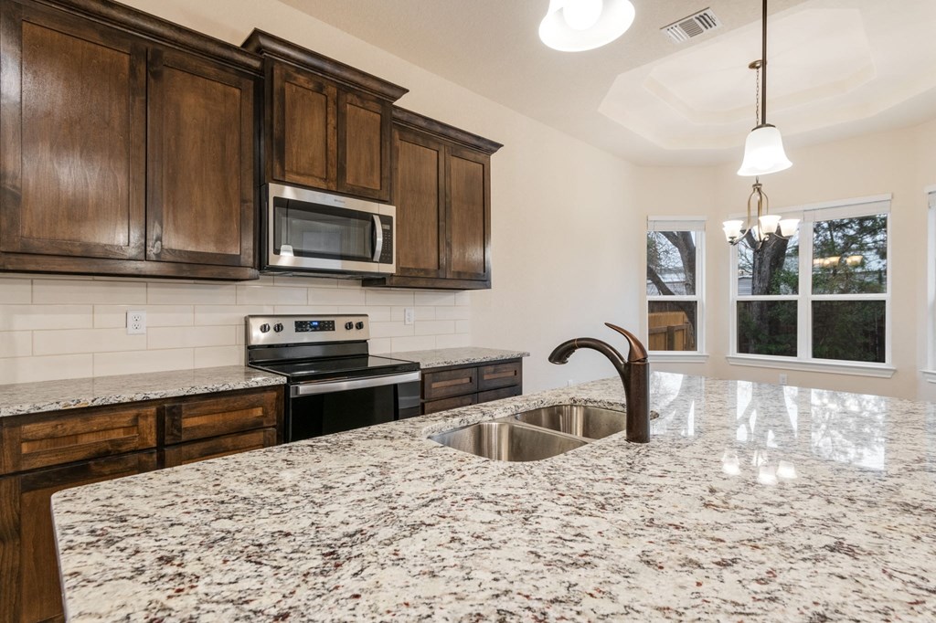 a kitchen with wooden cabinets and a granite counter top