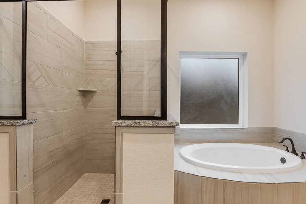 a bathroom with a tub and a shower and a sink