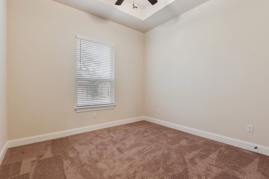 an empty room with carpet and a window