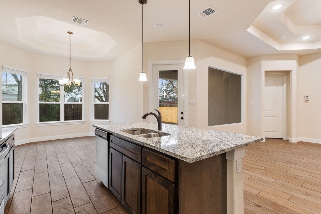 an open kitchen and living room with a granite counter top