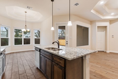 an open kitchen and living room with a granite counter top