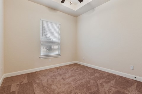 an empty room with carpet and a window