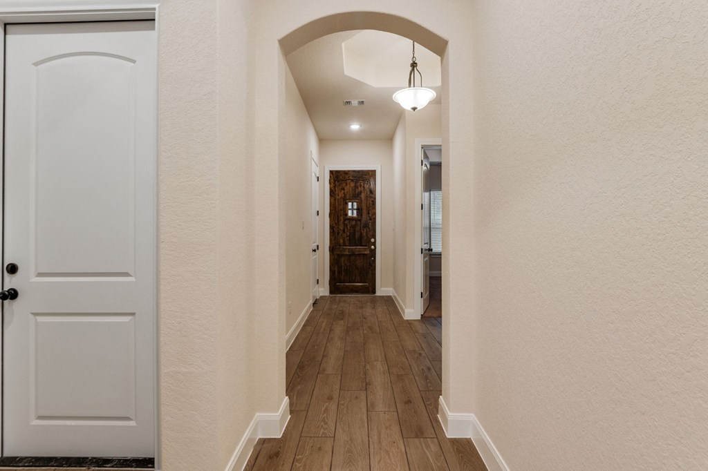 the hallway of a house with a door to a bathroom and a hallway with a