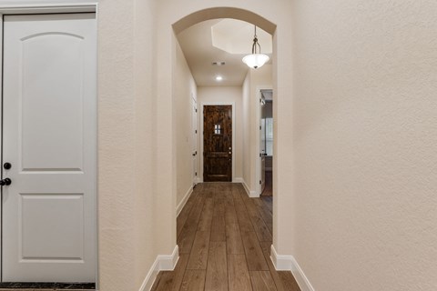 the hallway of a house with a door to a bathroom and a hallway with a