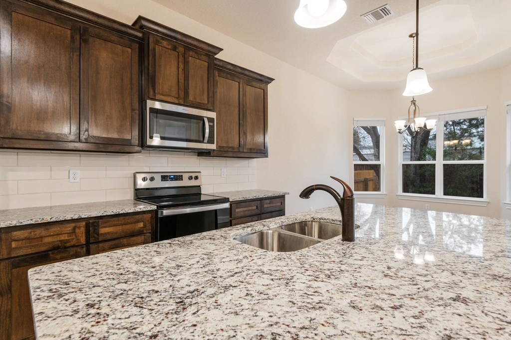 a kitchen with wooden cabinets and a granite counter top