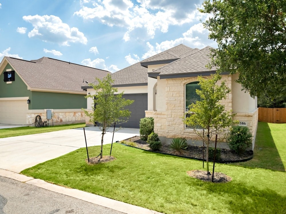 a house with a lawn and trees in front of it