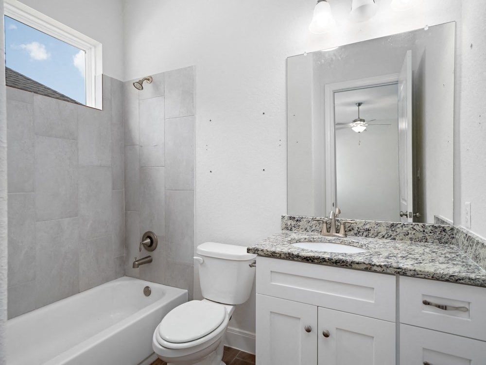 a bathroom with a toilet sink and tub and a mirror