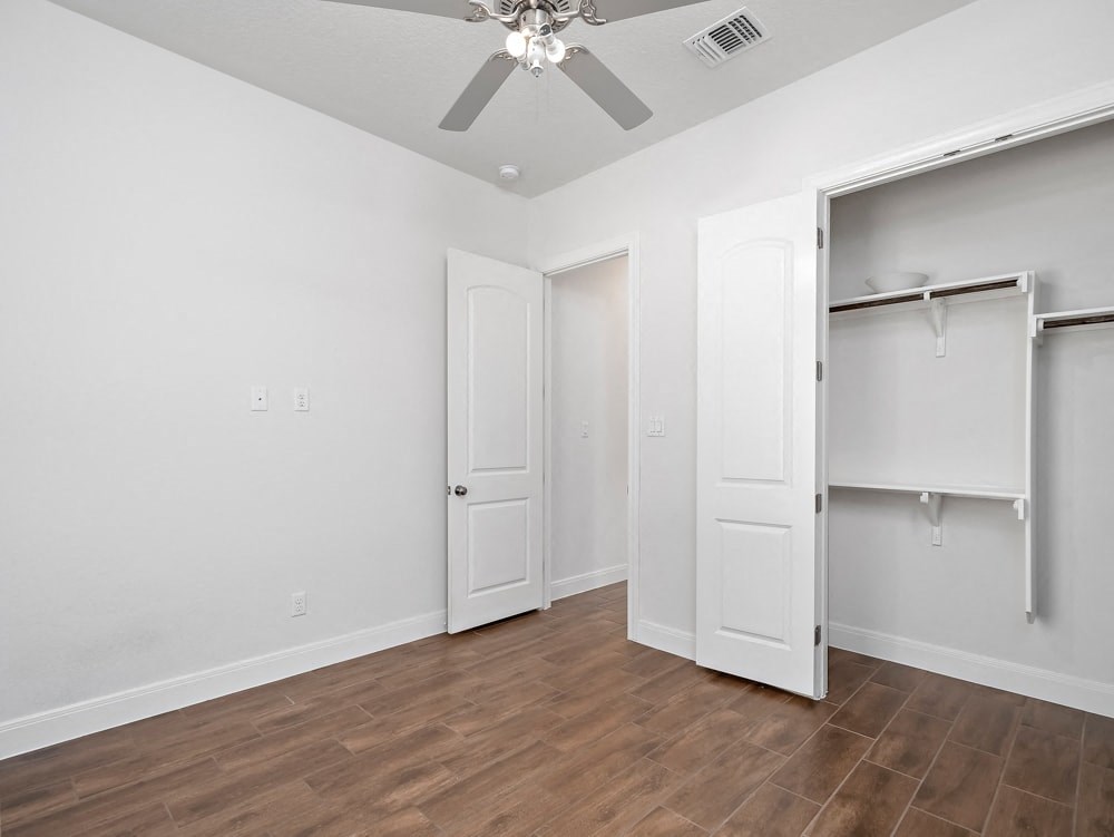 a bedroom with a closet and a ceiling fan