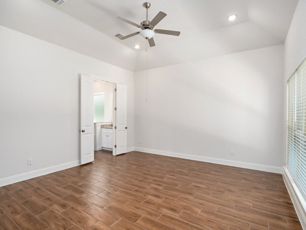 an empty living room with white walls and a ceiling fan