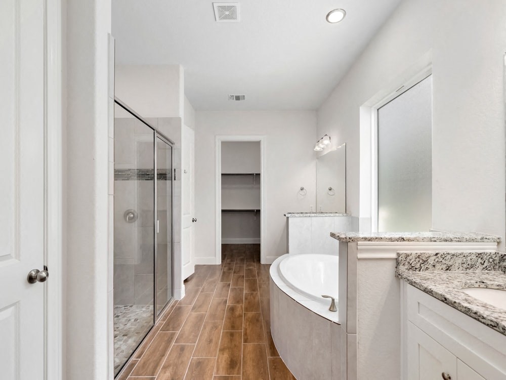 a white bathroom with a large tub and a shower