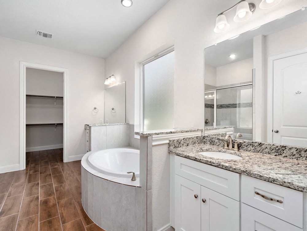 a bathroom with a tub and a sink and a mirror