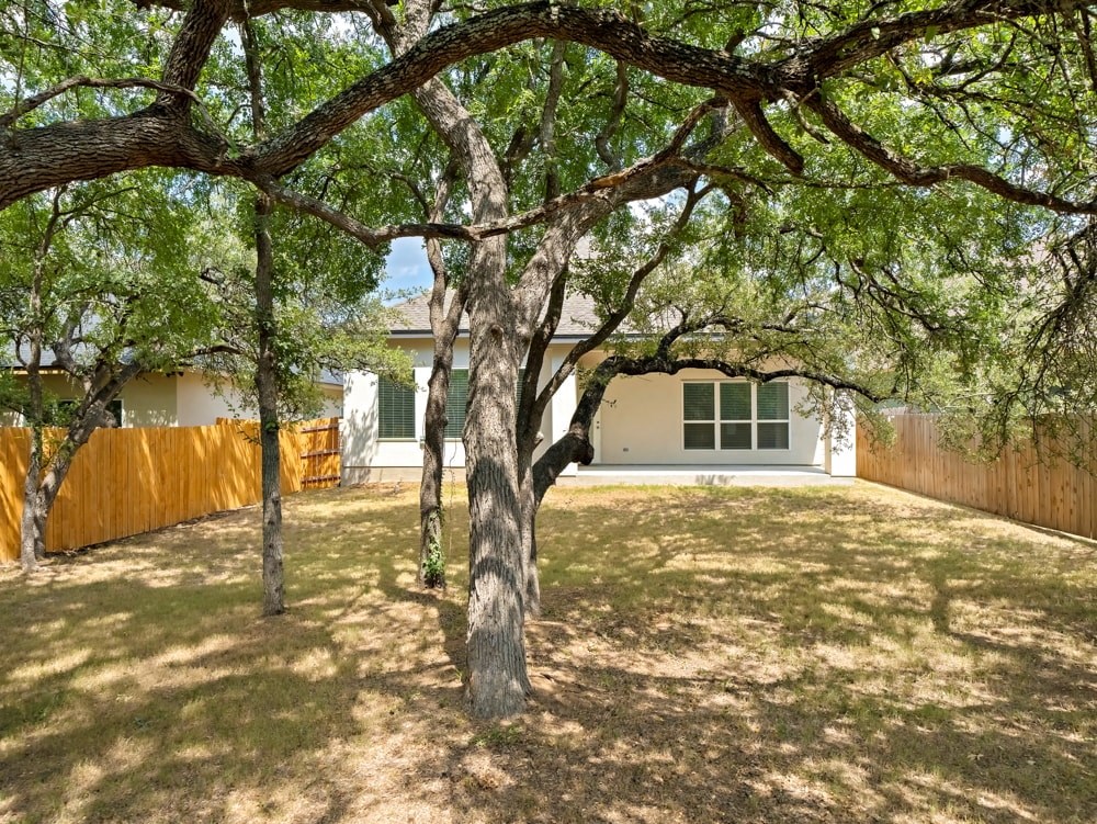 a yard with trees in front of a house
