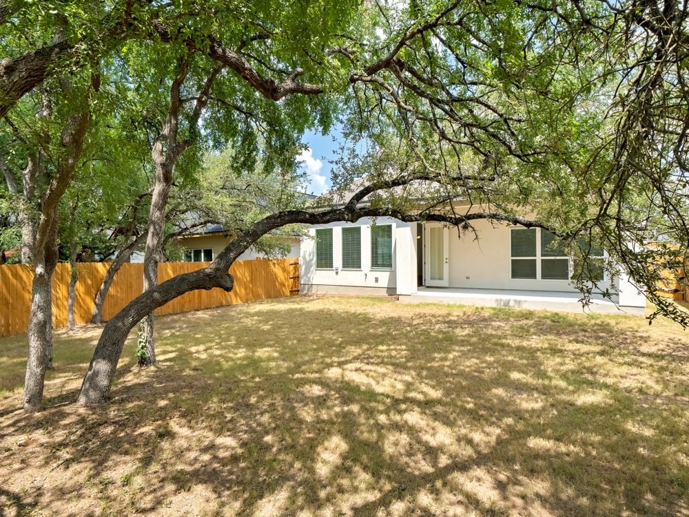 a yard with trees in front of a house