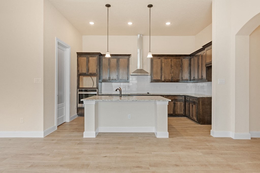 a kitchen with a white island and wooden cabinets