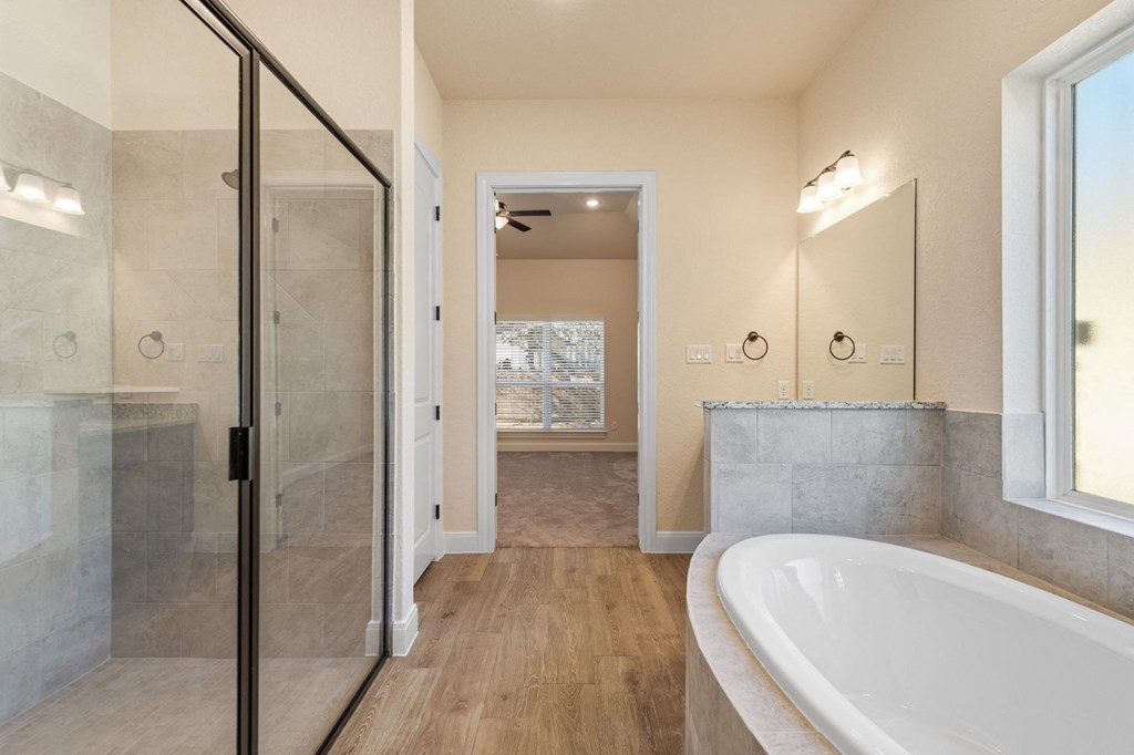 a bathroom with a large white tub and a shower