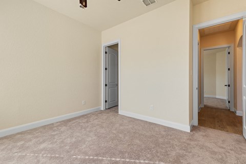 a bedroom with a carpeted floor and a door to a hallway