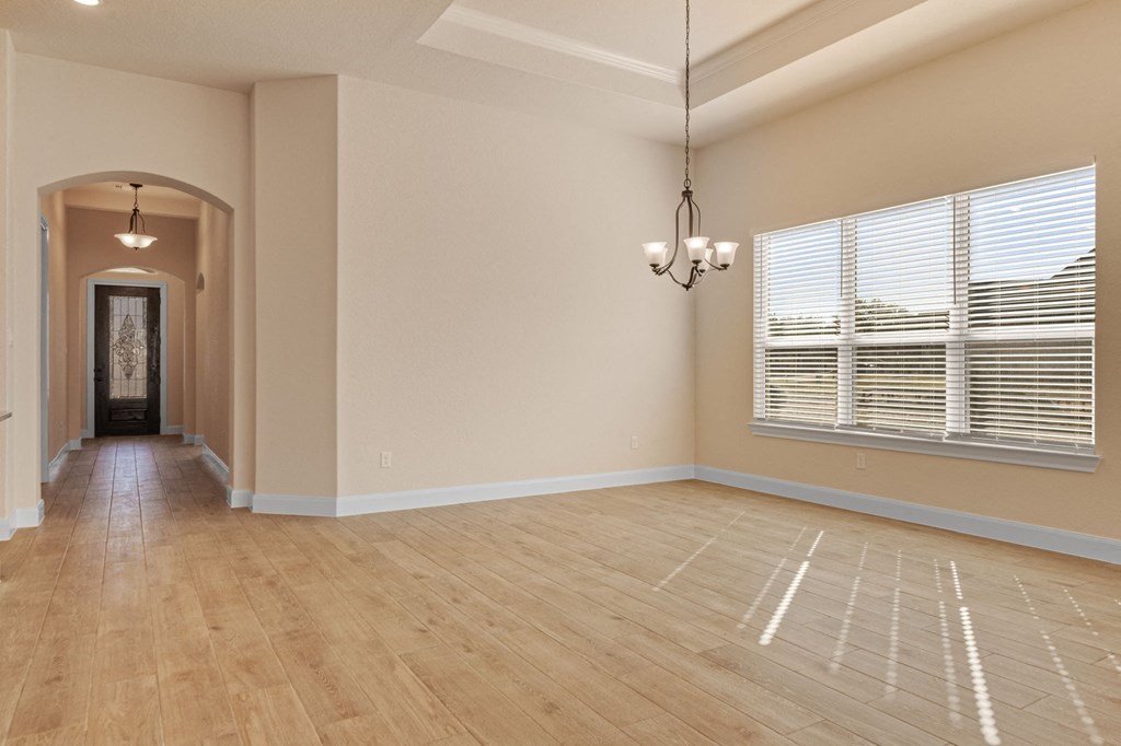 an empty living room with a large window and wood floors