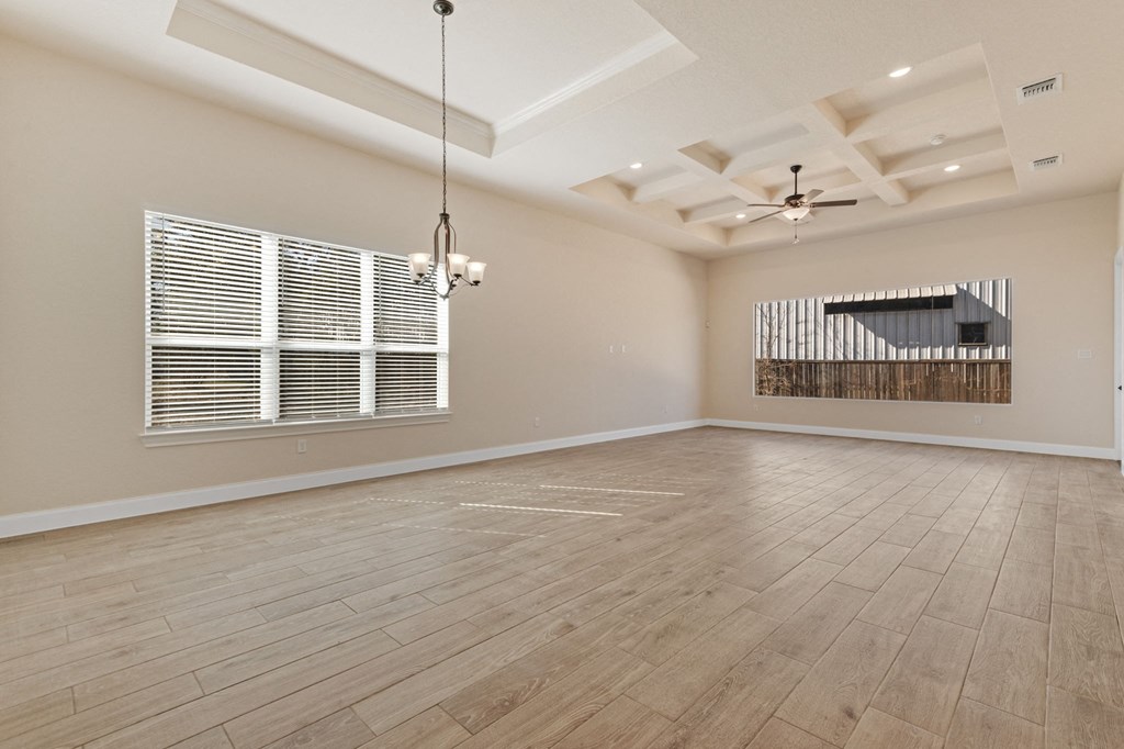 an empty living room with a large window and wood flooring