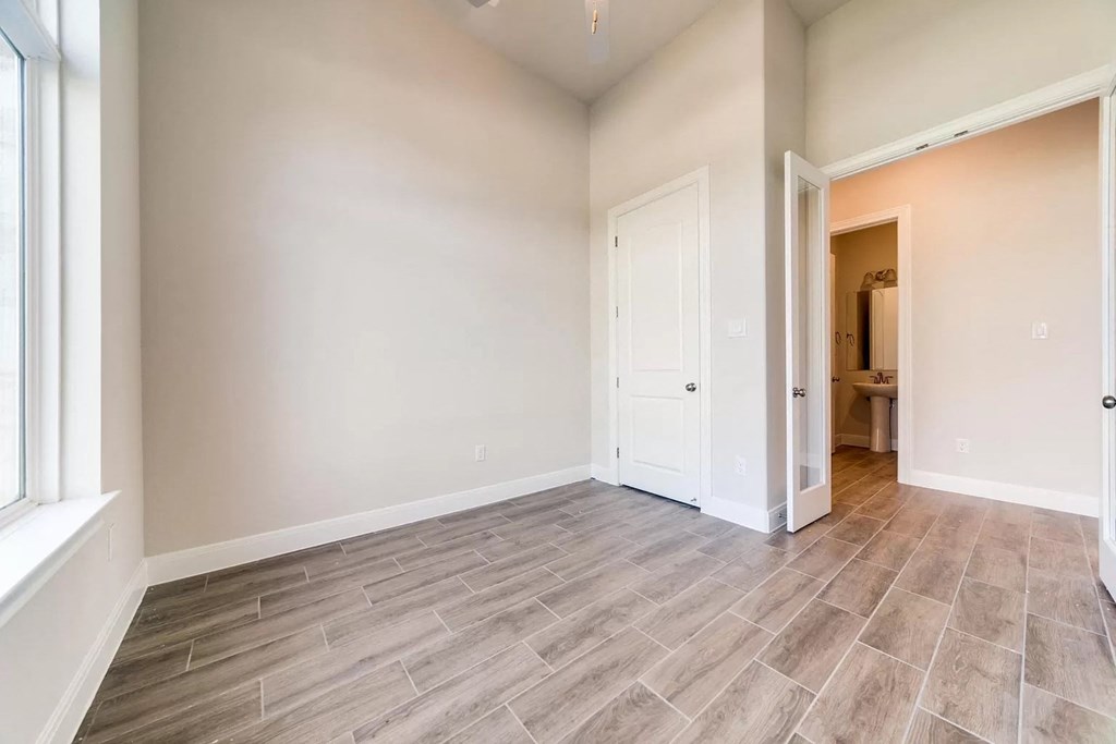 an empty living room with a door to a bathroom