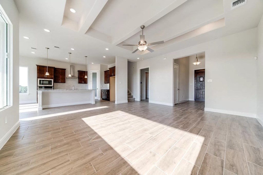 an open living room and kitchen with a ceiling fan