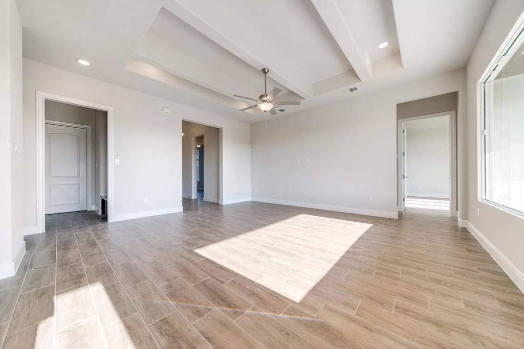 an empty living room with white walls and a ceiling fan