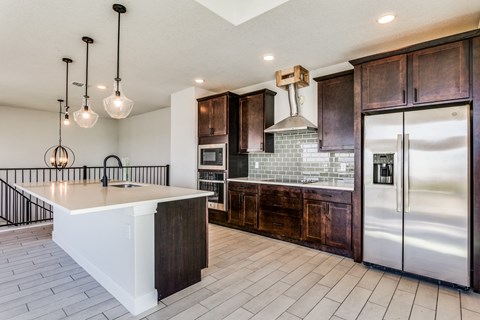 the kitchen has a large island and stainless steel appliances