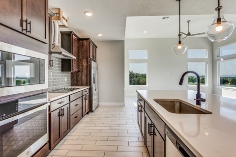 a large kitchen with wooden cabinets and a sink