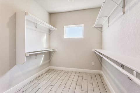 the spacious laundry room is equipped with shelves and a window