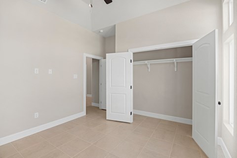 an empty room with a closet and a door to a bathroom